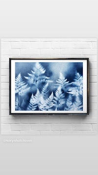 a blue and white fern print on a brick wall